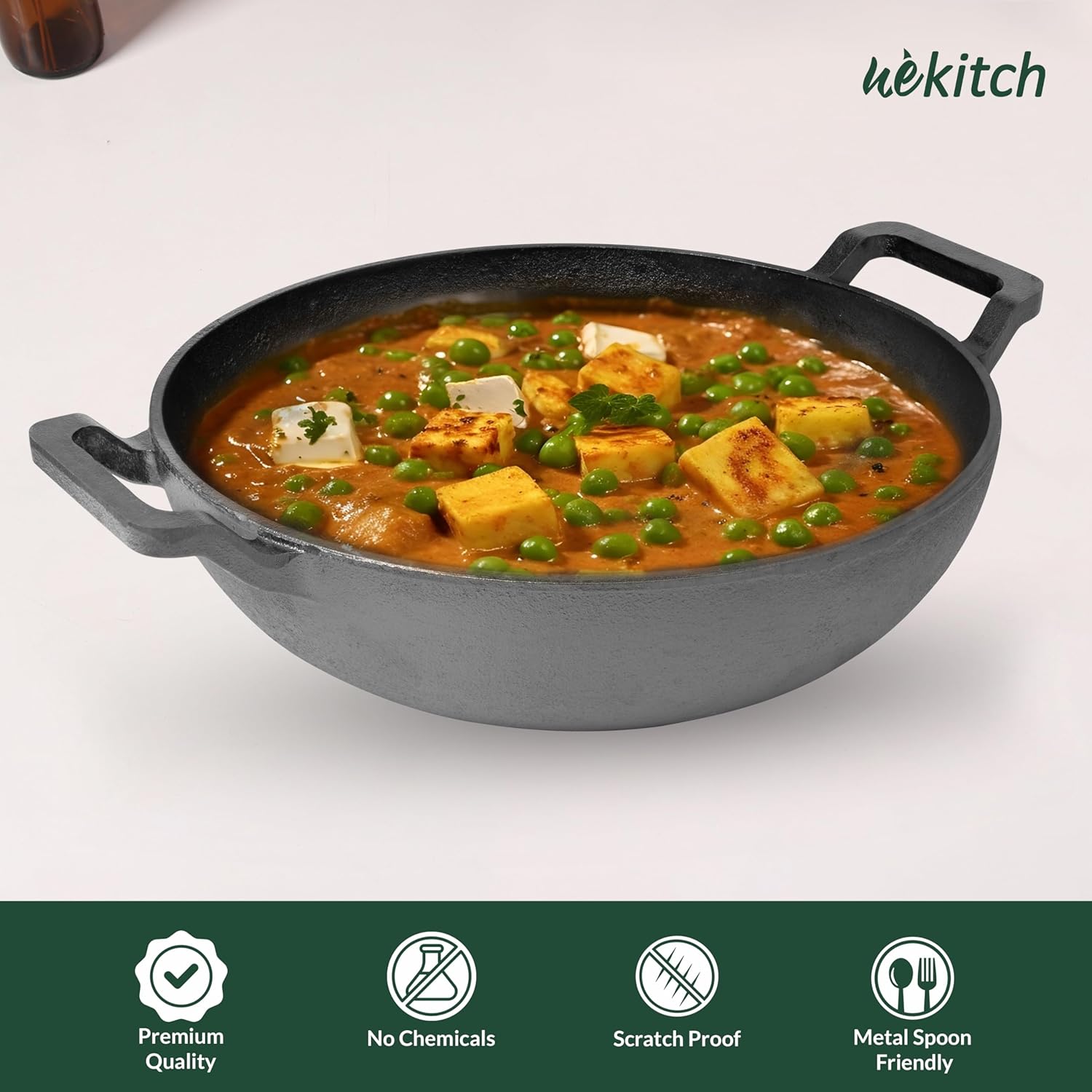 Dish of curry with vegetables in a gray cast iron skillet on a white background, featuring the brand 'Wekitch'.